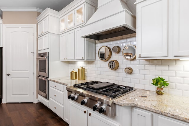 kitchen featuring dark wood-type flooring, white cabinetry, custom exhaust hood, appliances with stainless steel finishes, and crown molding