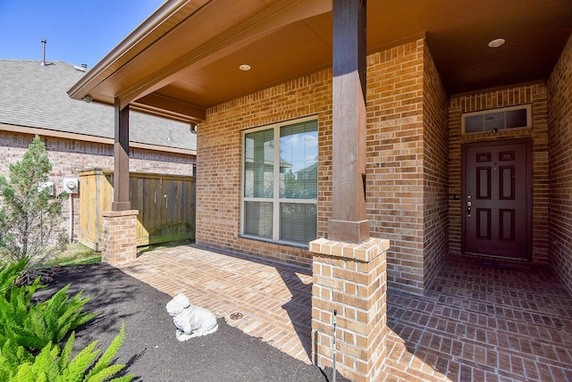 entrance to property featuring brick siding and a porch