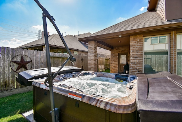 exterior space with a hot tub and fence