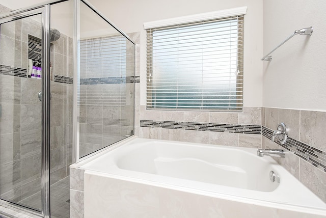 full bathroom featuring a garden tub and a shower stall