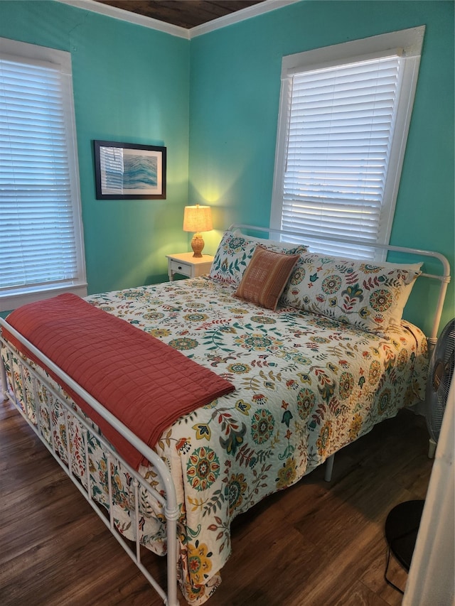 bedroom featuring crown molding and dark wood-type flooring