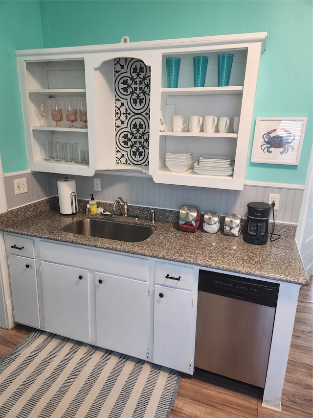 2219 33rd St E, Galveston, TX 77550 - kitchen featuring stainless steel dishwasher, open shelves, wainscoting, wood finished floors, and a sink