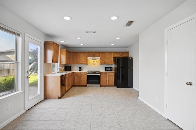 kitchen with a healthy amount of sunlight, decorative backsplash, sink, and black appliances