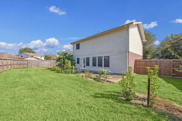 rear view of property featuring a yard and a patio