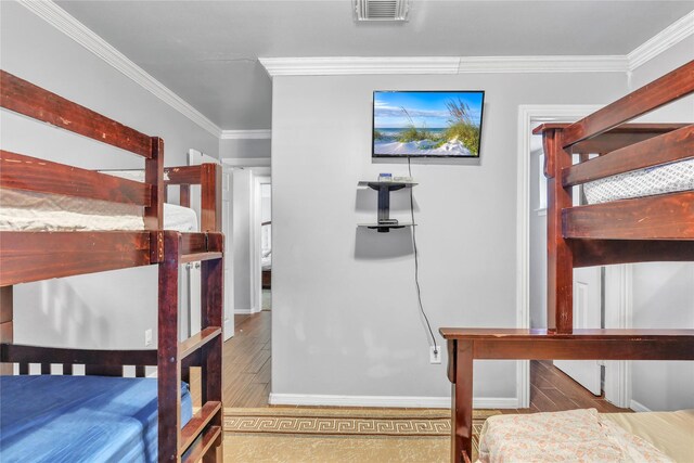 bedroom featuring wood-type flooring and crown molding