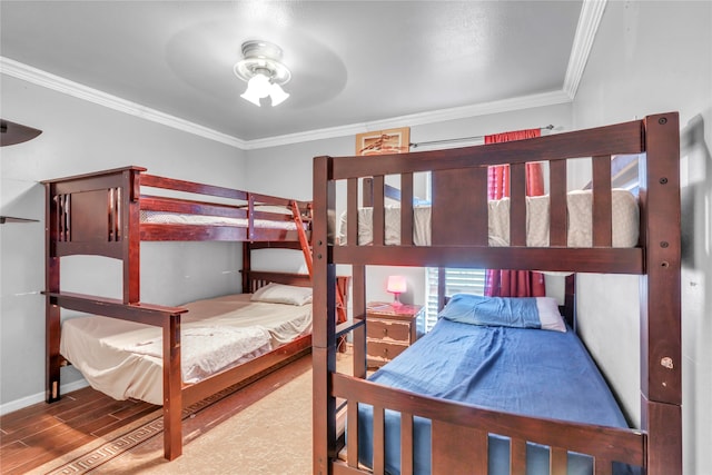 bedroom featuring ceiling fan, ornamental molding, and hardwood / wood-style floors