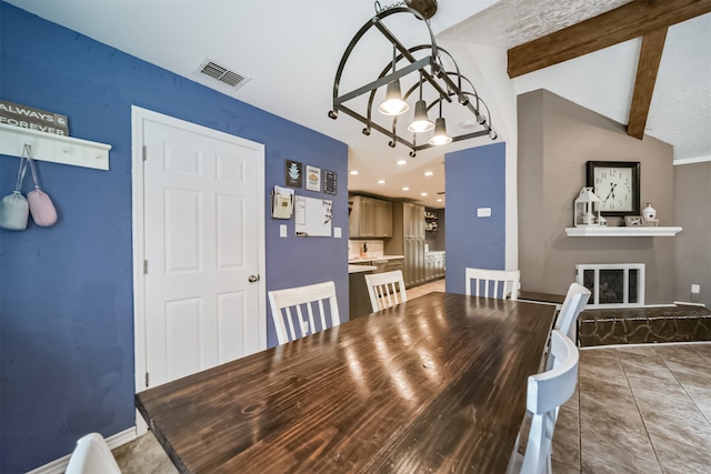 dining area featuring tile patterned flooring and lofted ceiling with beams