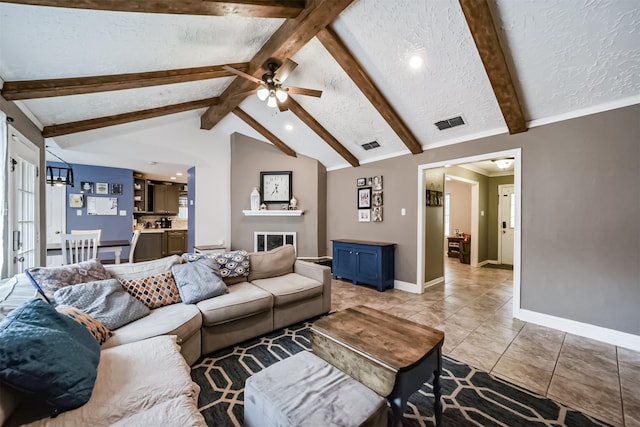 tiled living room with a textured ceiling, ceiling fan, and lofted ceiling