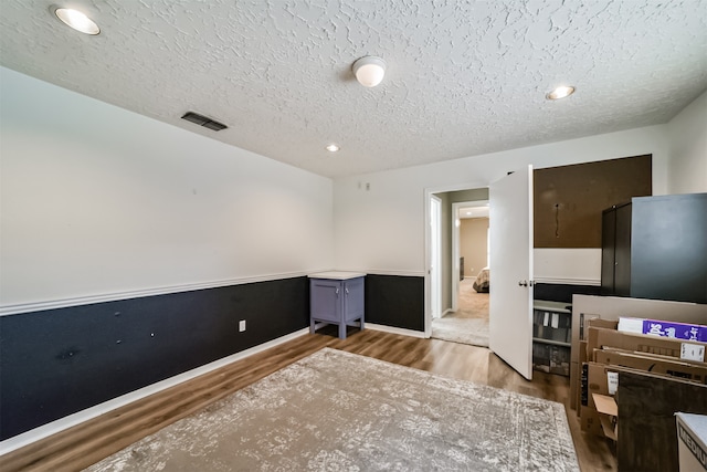 home office with a textured ceiling and hardwood / wood-style floors