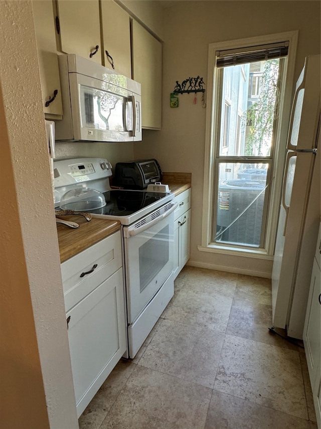 kitchen featuring white cabinets and white appliances