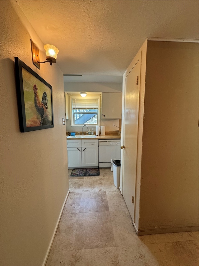 hallway featuring a textured ceiling and sink