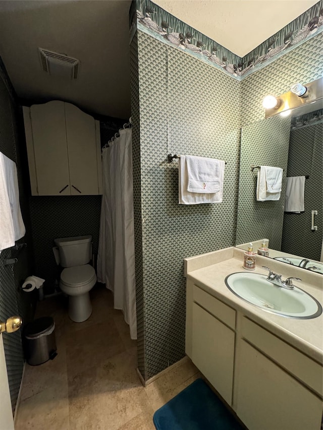 bathroom with curtained shower, vanity, and toilet