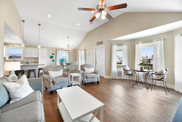 living room with dark hardwood / wood-style floors, ceiling fan with notable chandelier, and high vaulted ceiling