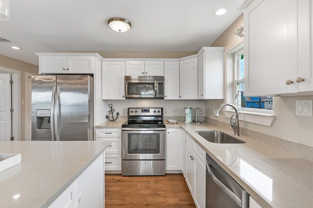 kitchen featuring dark wood-type flooring, sink, appliances with stainless steel finishes, and white cabinets