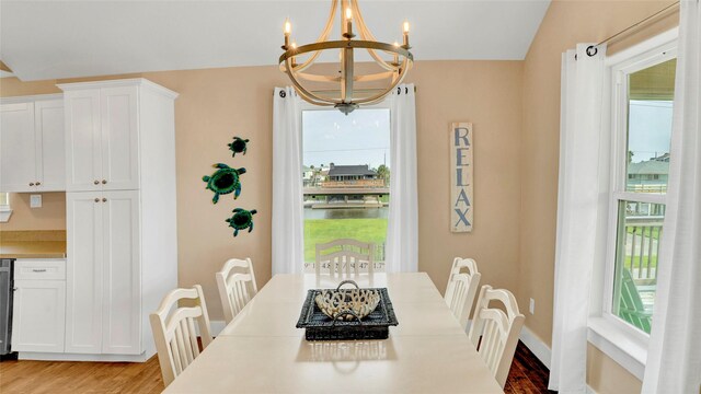 dining space with light hardwood / wood-style flooring and an inviting chandelier