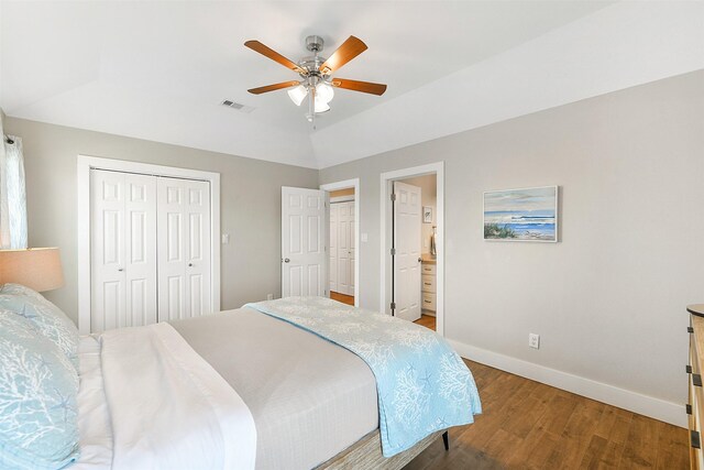 bedroom featuring hardwood / wood-style floors, ceiling fan, ensuite bathroom, and vaulted ceiling