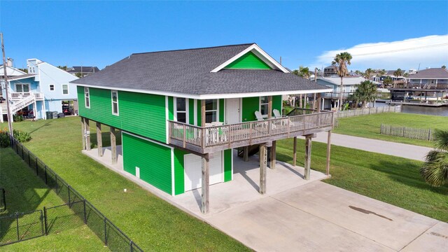 back of property with a lawn and a water view