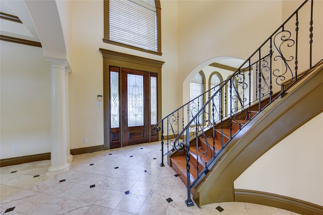 foyer entrance with a towering ceiling and decorative columns