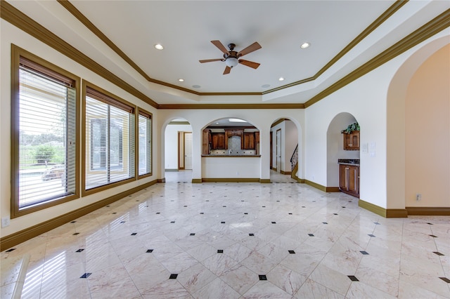 unfurnished living room featuring crown molding, ceiling fan, and a raised ceiling