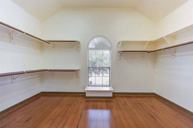 spacious closet with light wood-type flooring and vaulted ceiling