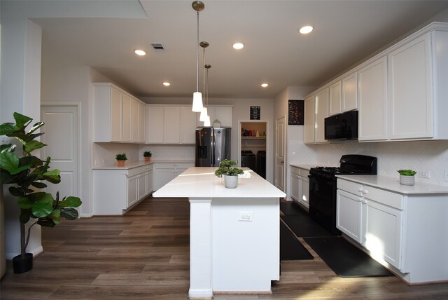 kitchen featuring a center island, white cabinetry, black appliances, and decorative light fixtures