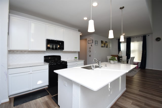 kitchen with a center island with sink, sink, black appliances, and white cabinets