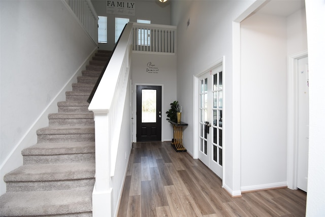 entryway with a high ceiling and wood-type flooring