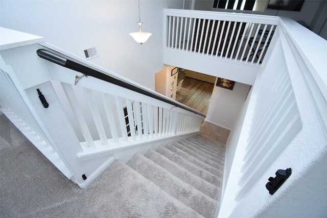 staircase featuring carpet