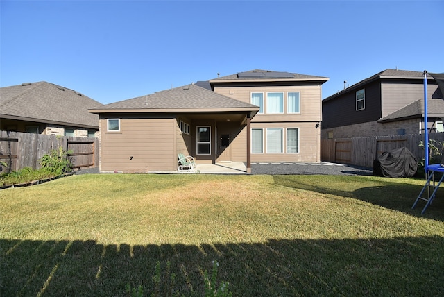 back of house featuring a patio and a lawn