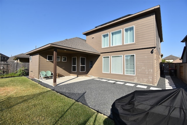 back of property with a patio and a lawn