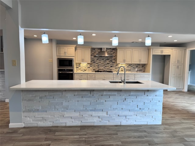 kitchen featuring stainless steel appliances, sink, decorative light fixtures, and cream cabinetry