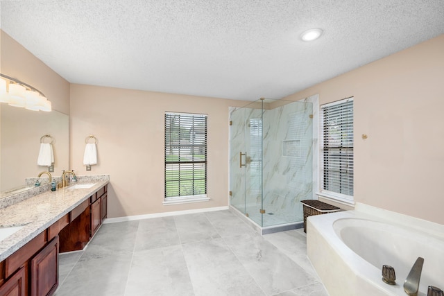 bathroom with tile patterned floors, vanity, a textured ceiling, and shower with separate bathtub