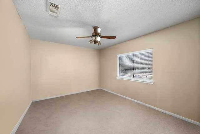 unfurnished room featuring ceiling fan, light colored carpet, and a textured ceiling