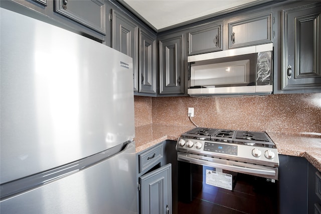 kitchen with light stone counters, appliances with stainless steel finishes, and tasteful backsplash