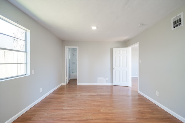 empty room featuring light wood-type flooring and plenty of natural light