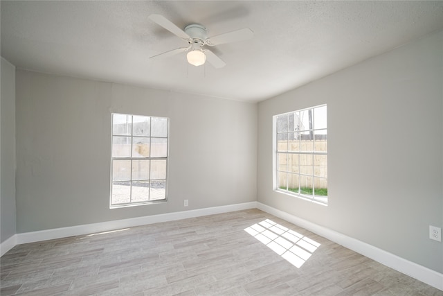 empty room featuring ceiling fan, a textured ceiling, and light hardwood / wood-style flooring