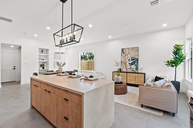 kitchen featuring built in features, a center island, and decorative light fixtures