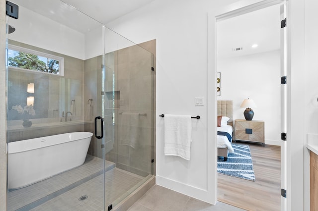 bathroom featuring vanity, plus walk in shower, and hardwood / wood-style flooring