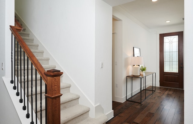 foyer entrance featuring crown molding and dark hardwood / wood-style floors