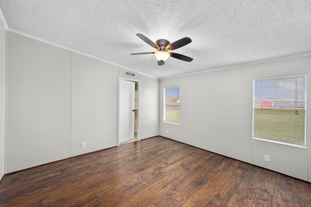 spare room with a textured ceiling, crown molding, dark wood-type flooring, and ceiling fan