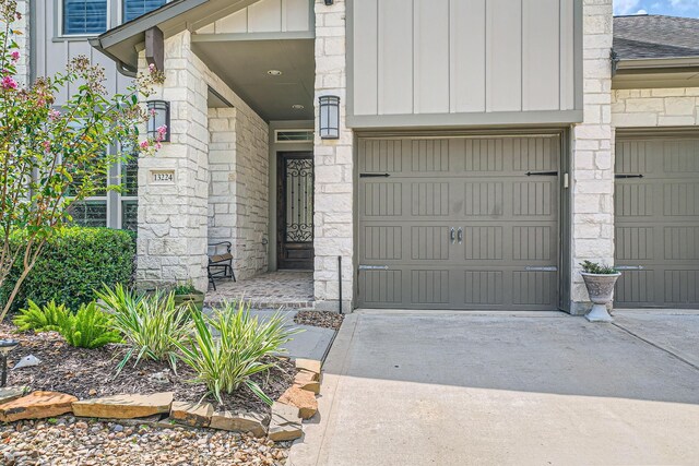 13224 N Salmon River Cir, Humble, TX 77346 - view of exterior entry featuring stone siding, board and batten siding, concrete driveway, and a shingled roof