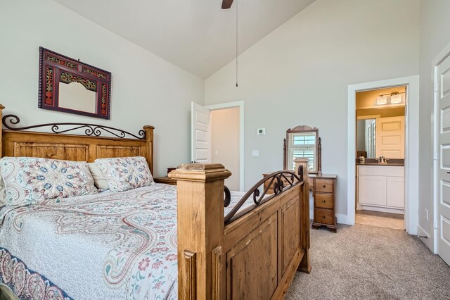 bedroom featuring a ceiling fan, high vaulted ceiling, a sink, light carpet, and connected bathroom