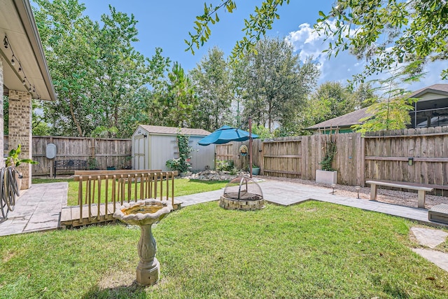 view of yard featuring a fire pit, a patio, and a shed