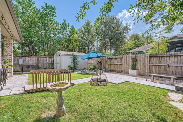 view of yard with a patio area, a fenced backyard, and an outdoor fire pit