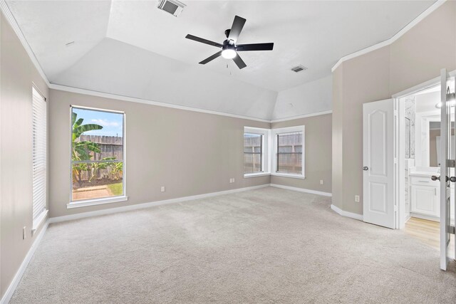 unfurnished bedroom featuring ceiling fan, ensuite bathroom, light colored carpet, lofted ceiling, and ornamental molding