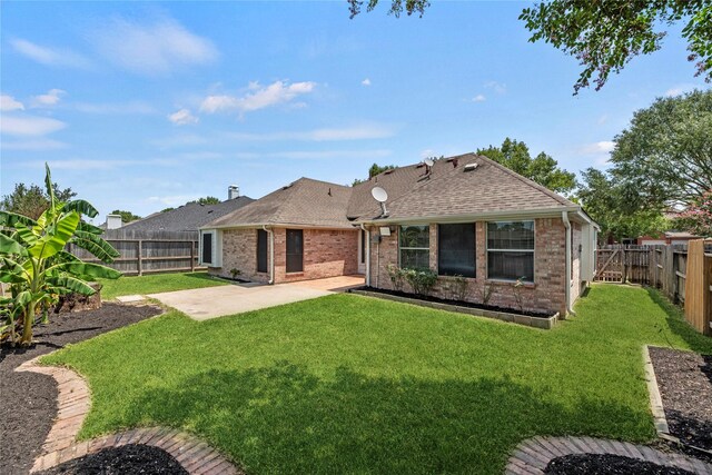 rear view of property featuring a yard and a patio area