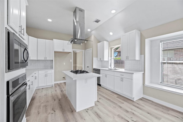 kitchen featuring a wealth of natural light, stainless steel appliances, a kitchen island, and white cabinetry