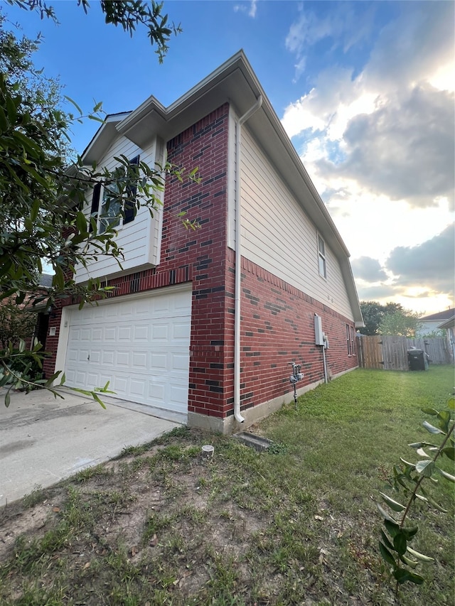 view of side of property featuring a garage and a yard