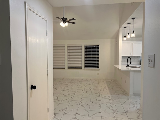 interior space with decorative backsplash, ceiling fan, and sink