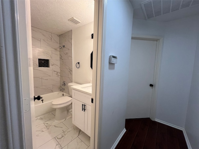 full bathroom featuring a textured ceiling, tiled shower / bath combo, vanity, and toilet